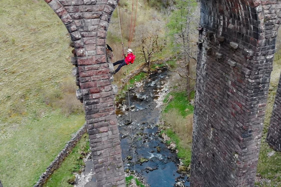 Aerial view of Smardale Viaduct with a rope-access worker on the arch