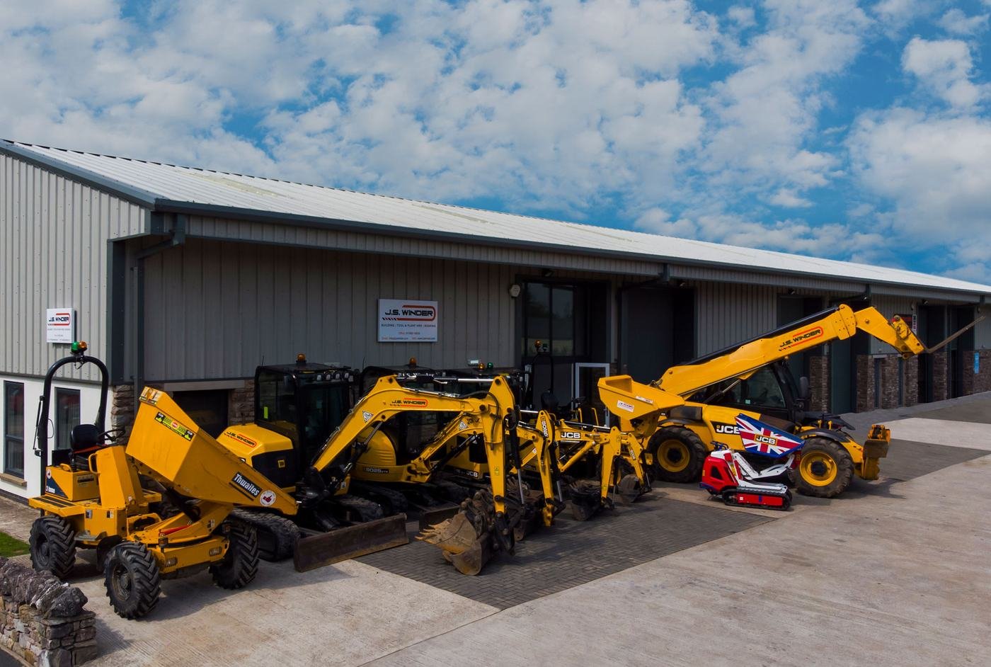 The J S Winder yard with yellow dumpers and diggers outside the depot